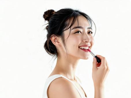 口紅を塗って微笑む明るい若い女性 口紅を塗って微笑む明るい若い女性の写真