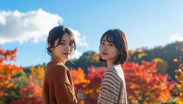紅葉の中でカメラ目線の2人の若い女性 紅葉の中でカメラ目線の2人の若い女性の写真