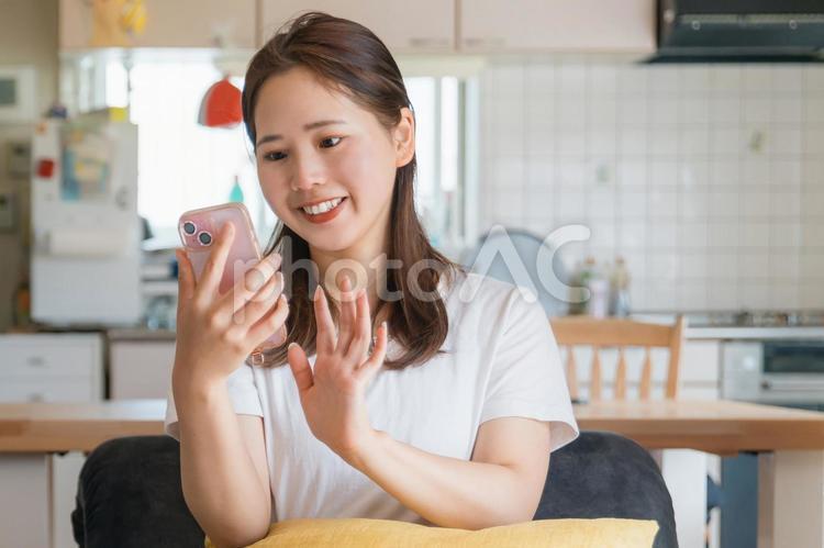 くつろぎながらスマホを使う女性 携帯,スマホ,メールの写真素材