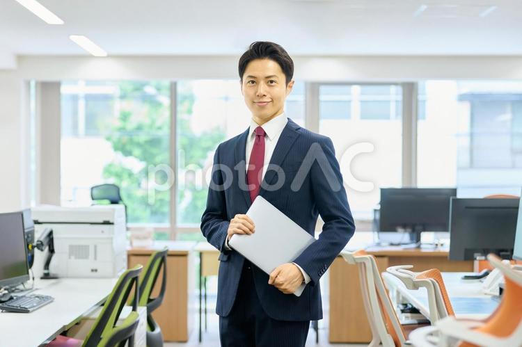 ノートパソコンを持つビジネスマン　会社 ビジネスマン,オフィス,ノートパソコンの写真素材