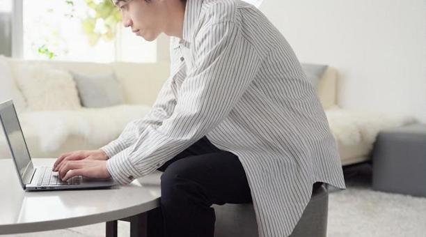 悪い姿勢でパソコン作業をするアジア人男性 悪い姿勢でパソコン作業をするアジア人男性 タイピング,姿勢,腰の写真素材