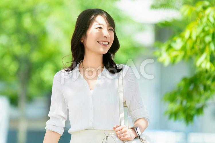 屋外を歩く笑顔の女性・ビジネスウーマン 女性,歩く,夏の写真素材
