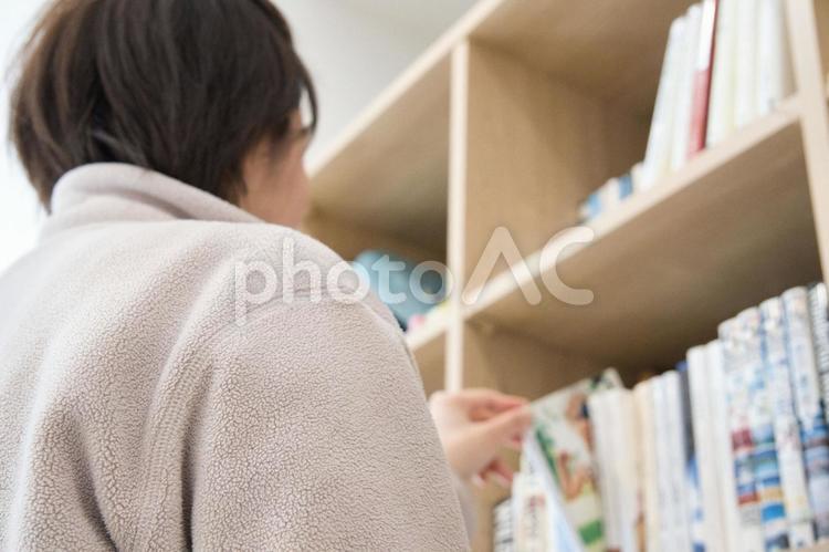 本棚から好みの本を選ぶ女性の手 本,本棚,選ぶの写真素材