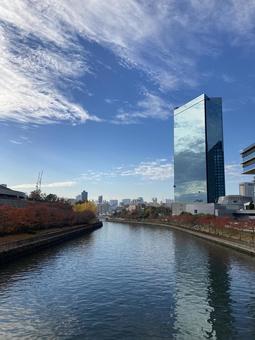 秋晴れの川沿いと高層ビル 秋晴れの川沿いと高層ビルの写真