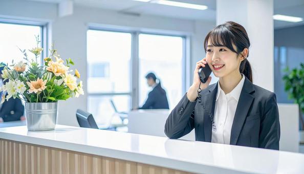 笑顔で対応する女性の受付嬢 笑顔で対応する女性の受付嬢の写真