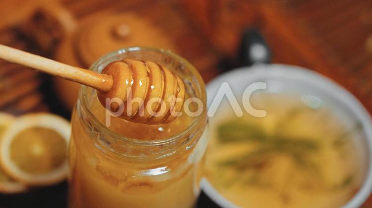蜂蜜を瓶からハニーディッパーで出したところ 瓶,紅茶,茶器の写真素材