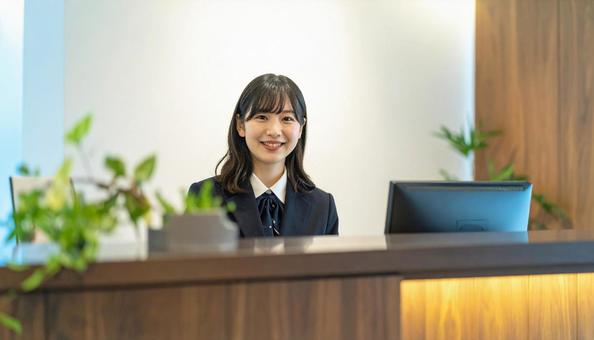 笑顔で対応する女性の受付嬢 笑顔で対応する女性の受付嬢の写真