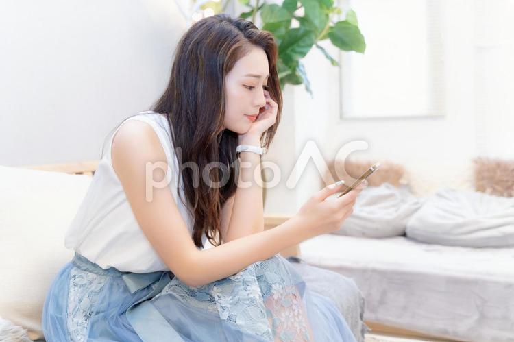 スマホを眺める女性の横顔 女性,スマホ,スマートフォンの写真素材