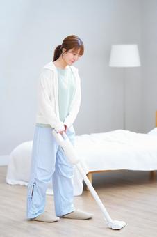 微笑みベッドまわりを掃除する女性 女性,掃除機,掃除の写真素材