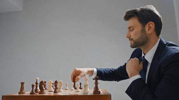 チェスをする横向きのスーツの男性(グレー背景) チェスをする横向きのスーツの男性(グレー背景) チェス,男性,30代の写真素材