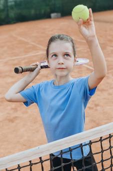 テニスボールを上に掲げる女の子 女の子,子供,外国人の写真素材