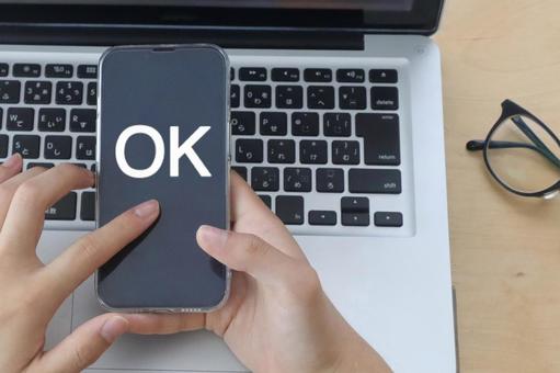 スマホを持つ男性の手 OKイメージ スマホを持つ男性の手 OKイメージ ok,オーケー,文字の写真素材