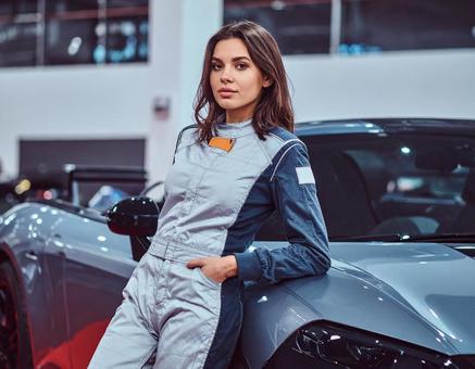 車に寄りかかるレーシングスーツの女性 車に寄りかかるレーシングスーツの女性の写真