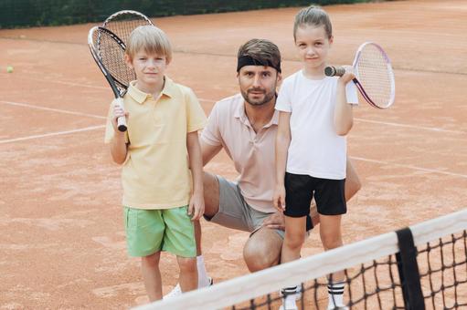 ネット越しに笑顔のコーチと子供たち 親子,子供,外国人の写真素材