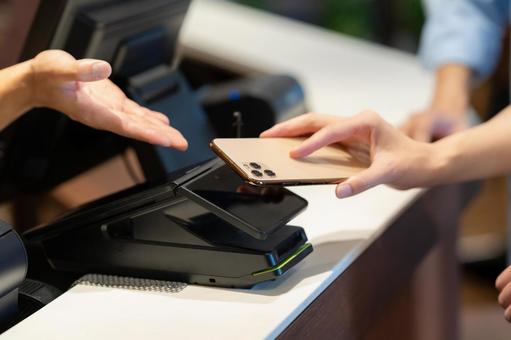 ショッピングをしてモバイル決済をする女性 モバイル決済,ショッピング,買い物の写真素材