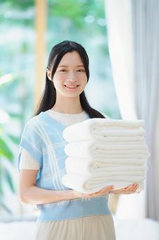 両手でタオルを持ちカメラ目線で笑う女性 女性,日本人,タオルの写真素材