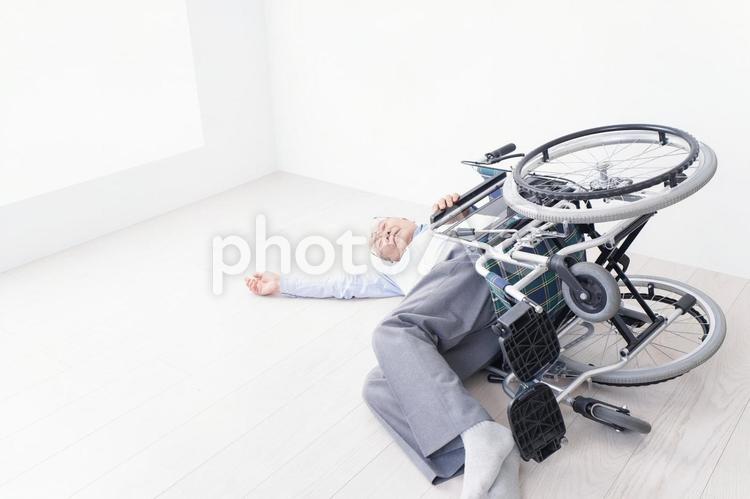 車椅子から転倒した高齢の男性 リハビリ,保険施設,助けの写真素材