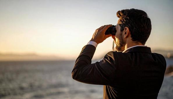 双眼鏡で海の先を見ている男性 双眼鏡で海の先を見ている男性の写真