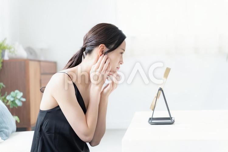 鏡を見て不満げな女性 悩む,自宅,準備の写真素材