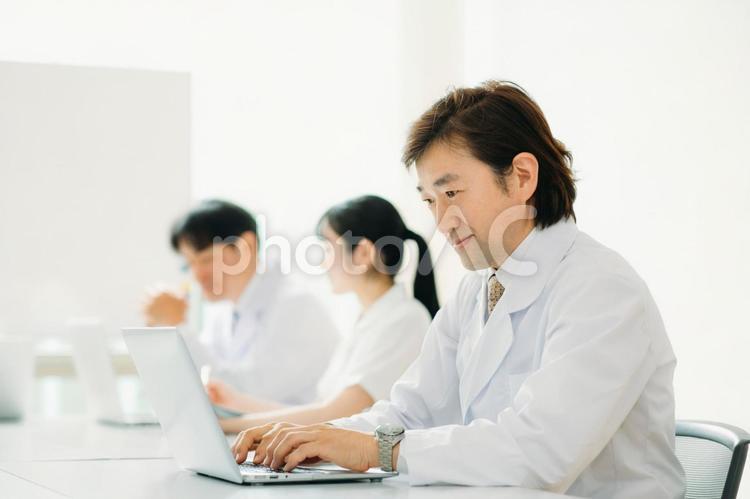白衣を着た男性（パソコン・笑顔） 医者,オンライン診療,パソコンの写真素材