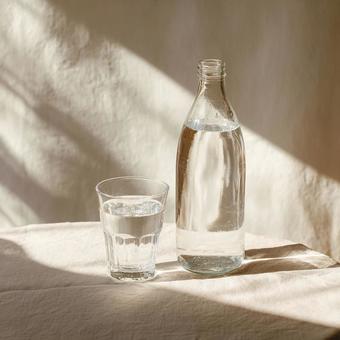 テーブルに置かれたグラスと水の瓶の写真