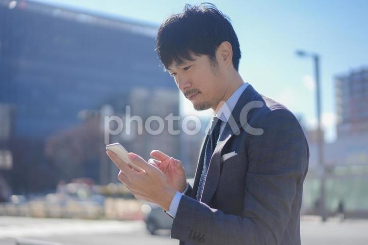 グレースーツの街中のビジネスマンとスマホ3 人物,ビジネス,男性の写真素材