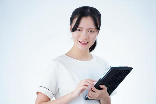 女性がタブレットを持ってこちらを見る 女性,タブレット,持つの写真素材