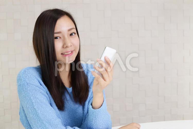 スマートフォンを持つ笑顔の女性 女性,スマートフォン,女の写真素材