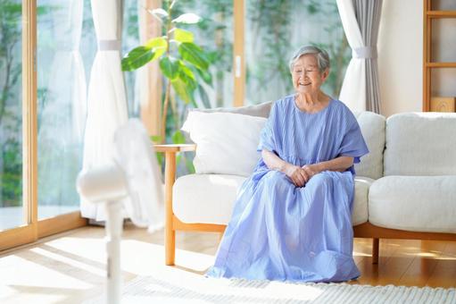 扇風機で涼むソファに座る高齢女性 女性,ソファ,座るの写真素材