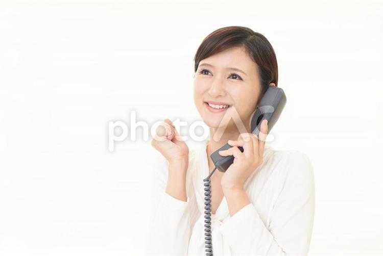 受話器を持ってガッツポーズをする女性 女性,ビジネスウーマン,仕事の写真素材