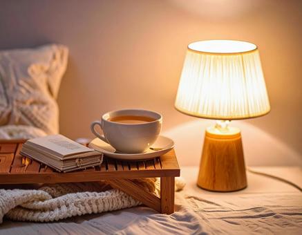 おしゃれな部屋に灯る照明とコーヒーカップの写真