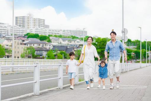 手を繋いで屋外を散歩する親子 手を繋いで屋外を散歩する親子 人物,家族,女性の写真素材