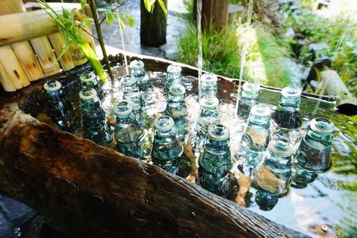 冷水に浸かったラムネ瓶 冷水に浸かったラムネ瓶の写真