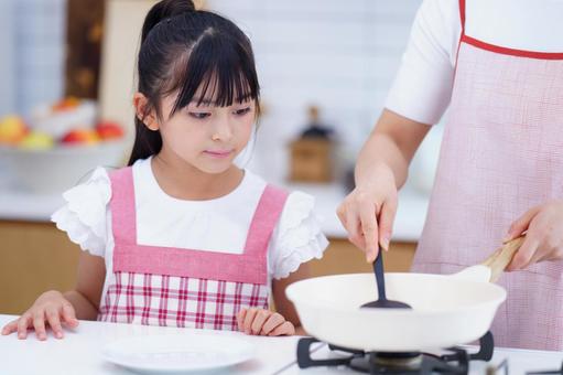 料理を楽しむ親子のクッキングシーン 女の子,料理,フライパンの写真素材