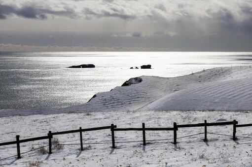 冬光が照らす海と雪丘の静景 冬,海,海岸の写真素材