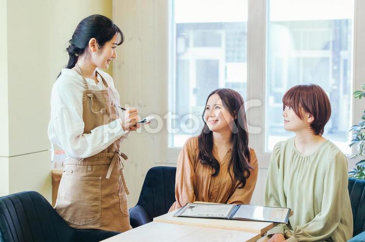 メニューを選ぶ客とカフェスタッフ カフェ,メニュー,注文の写真素材