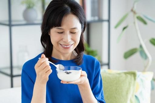 ヨーグルトを食べるミドルの女性 ヨーグルトを食べるミドルの女性の写真