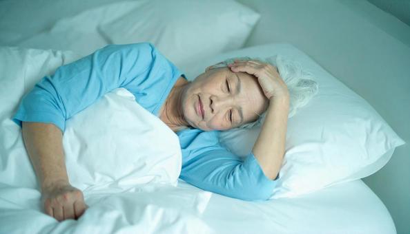 夜、眠れずに悩むシニア女性の横顔 夜、眠れずに悩むシニア女性の横顔の写真