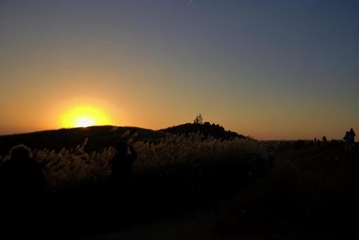 夕焼けとススキの丘を歩く人々のシルエット 夕焼けとススキの丘を歩く人々のシルエット 夕焼け,空,ススキの写真素材