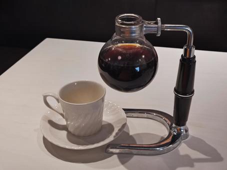 サイフォンコーヒーポットとコーヒーカップ サイフォンコーヒーポットとコーヒーカップの写真