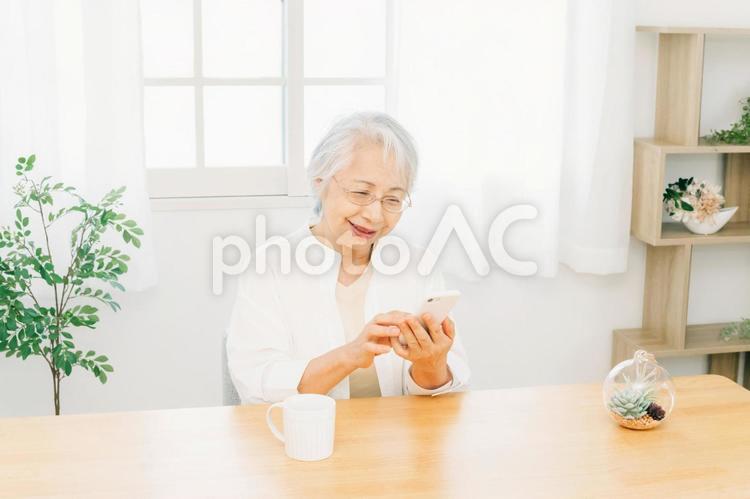 スマホを使う高齢者女性（笑顔） スマホ,高齢者,携帯電話の写真素材