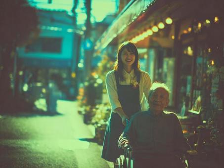 車いすにのっている男性をおすヘルパーさん 車いすにのっている男性をおすヘルパーさんの写真