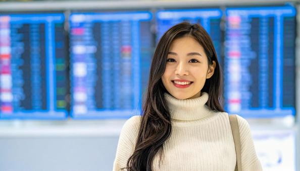 空港で笑顔の日本人女性旅行者の写真