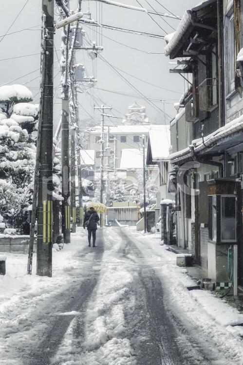 滋賀県彦根市の雪景色と彦根城が遠くに見える路地の風景 雪,町並み,滋賀県の写真素材