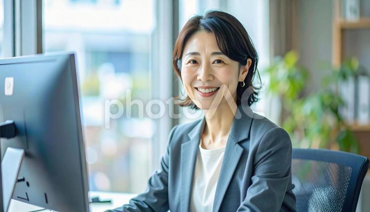 オフィスでパソコン操作をする女性 女性,パソコン,笑顔の写真素材