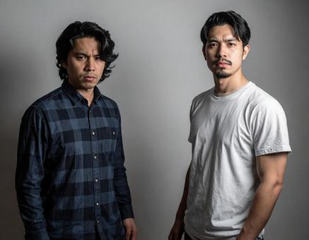 不満な表情をしている日本人男性2人組 不満な表情をしている日本人男性2人組の写真