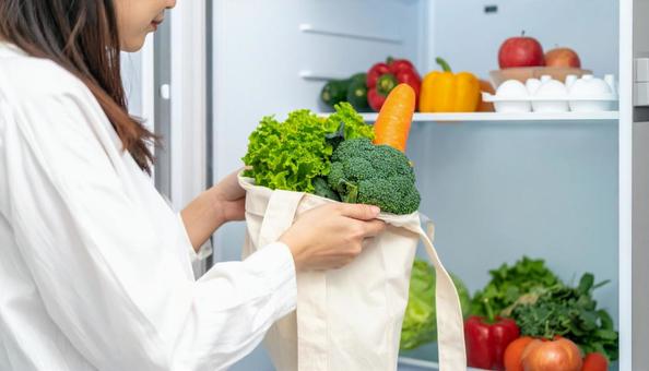 エコバッグから野菜を取り出し冷蔵庫へ エコバッグから野菜を取り出し冷蔵庫への写真
