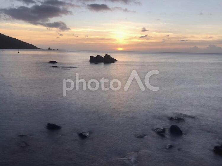 静かな海に沈む夕日と小島のシルエット 夕暮れ,夕日,夕焼けの写真素材