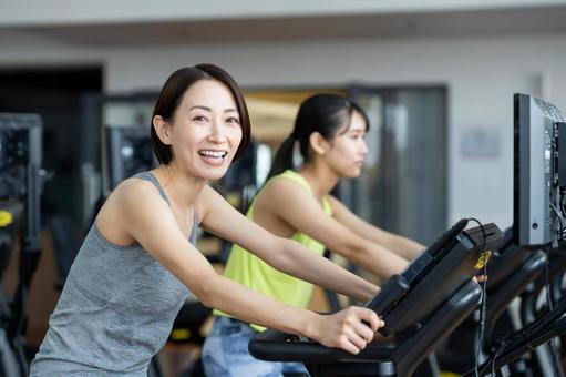 ジムでトレーニングするミドルの女性の写真