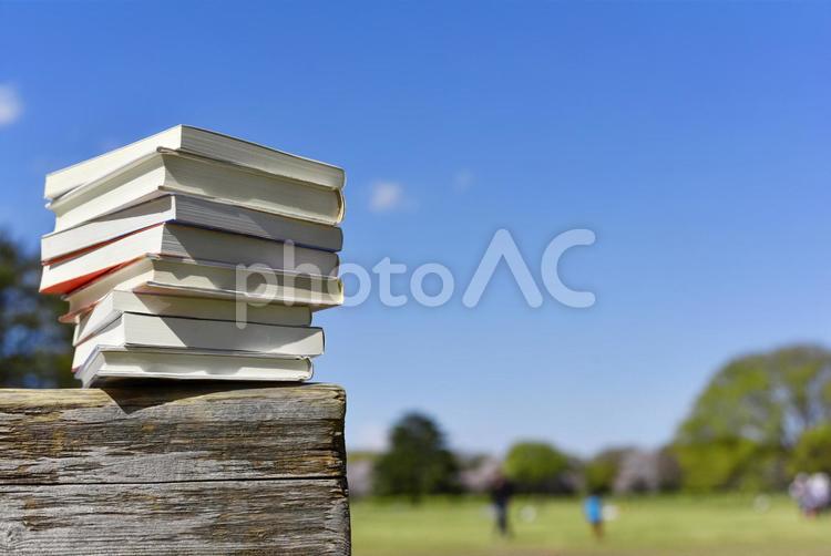読書のイメージ　木製ベンチの上に積み上がった本と青空 読書,本,書籍の写真素材